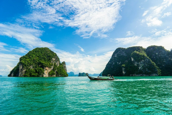 a boat in the water with a group of islands in the background